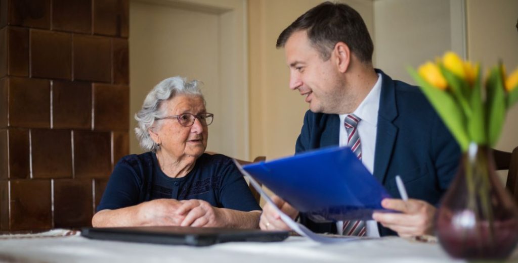 Professional talking with elderly woman