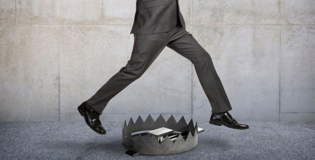 Businessman jumping over bear trap